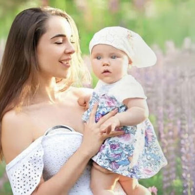 Tire lait électrique portable utilisé dans un champ par une jeune maman