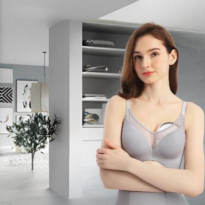Femme utilisant un tire-lait mains libres, pratique et discret sous les vêtements.