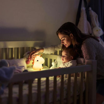 Veilleuse bébé UnicornGlow™ posée près du berceau, créant une atmosphère sécurisante pour bébé.